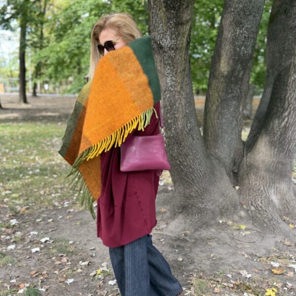 Green and orange fringed scarf wrapped around the shoulders — side view