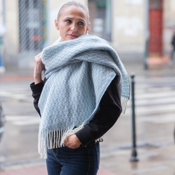 Pale blue and ecru scarf — wrapped around the neck, showing the pattern and fringes